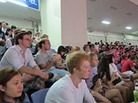 Students and other audience cheer for sumo wrestlers