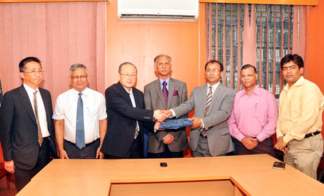 Shaking hands between Prof. F. Suzuki and Prof. K. Uddin in the presence of Vice-Chancellor of University of Dhaka and other attendees