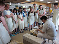 Students listen to the instructions about how to throw a cup or bowl