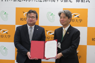 協定書を手にする後藤理事長（右）と益川センター長