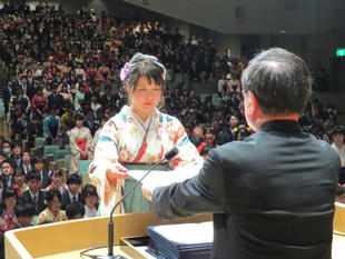 President Moriwaki handing out a diploma to a student