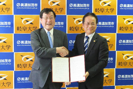 協定書を手にする森脇学長（左）と伊藤市長