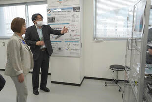 研究棟において、研究者から最先端設備の説明を熱心に聞き入る永岡文部科学大臣