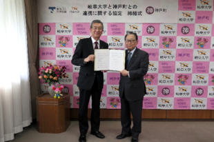 協定書を手にする（左）藤井町長と吉田学長