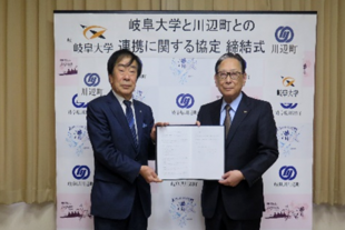 協定書を手にする（左）佐藤町長と吉田学長