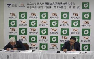 協定書にサインする佐伯町長（左）と吉田学長