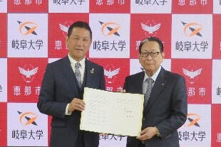 協定書を手にする（左）小坂市長と吉田学長