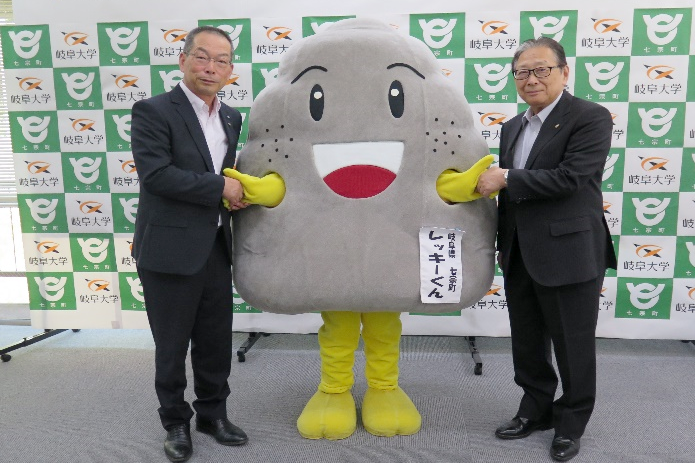 協定書を手にする加納町長と吉田学長、七宗町公認キャラクター　レッキーくん