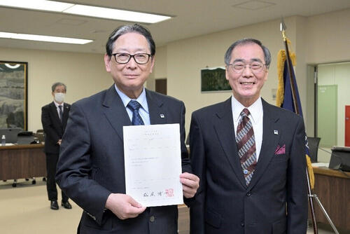 辞令を受けた吉田学長（左）と機構長